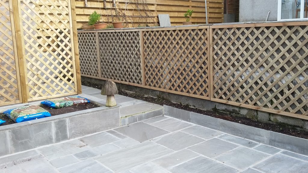 laying a garden patio with raised beds and fencing